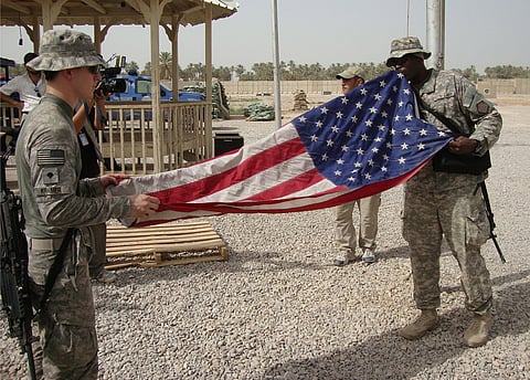 Soldados dobram a bandeira dos EUA aquando da sua partida de uma base em Najaf, 2010. As tropas de combate norte-americanas foram retiradas do Iraque em 2011. Permaneceu um grupo reduzido até 2014, altura em que o Estado Islâmico pôs em risco a sobrevivência do país e levou ao regresso de forças estrangeiras lideradas pelos EUA. 