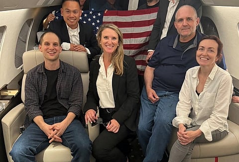 Evan Gershkovich (esq.), Paul Whelan e Aslu Kurmasheva (dir.) no avião de regresso a casa.