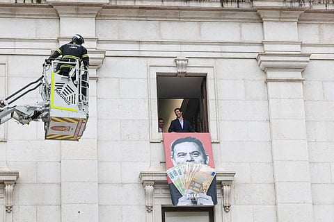 Bombeiros a retirar as tarjas do Chega colocadas na fachada da Assembleia da República,
