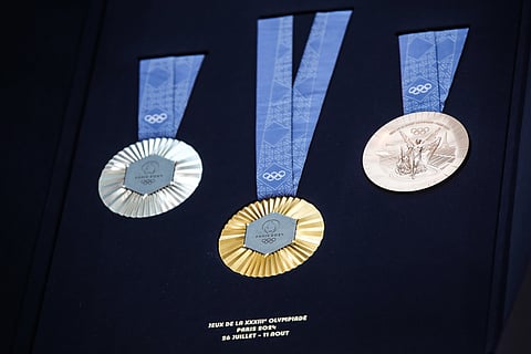 Uma peça hexagonal de ferro polido retirado da Torre Eiffel foi colocado no centro das medalhas.