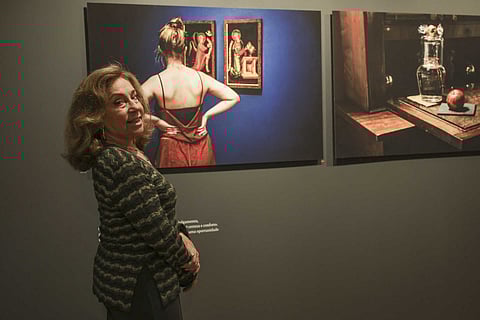 Evelyn Kahn junto de duas  (de um conjunto de 41) das suas fotografias expostas no Museu Medeiros e Almeida, em Lisboa.