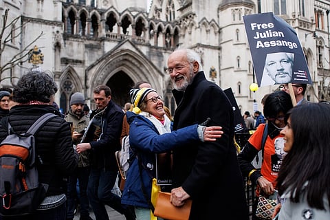 Uma ativista cumprimenta John Shipton, o pai de Julian Assange, em frente do tribunal, em Londres. EPA/TOLGA AKMEN
