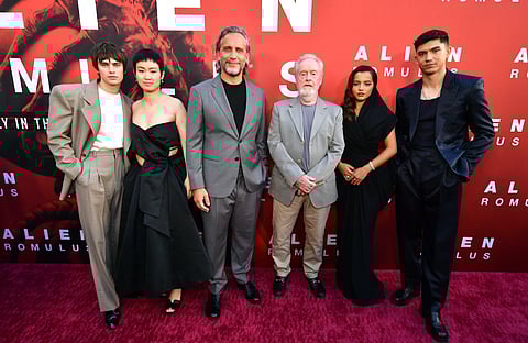 Fede Alvarez e Sir Ridley Scott ladeados pelos membros do elenco.