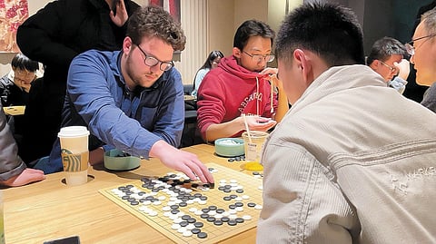 Hoje em dia, cada vez mais entusiastas de Go gostam de jogar em cafés. Aqui, um americano jogava Go num café, em Xangai, em janeiro de 2024.