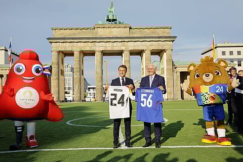 Macron e Steinmeier na Porta de Brandemburgo com as mascotes do Euro de futebol e dos Jogos Olímpicos de Paris.