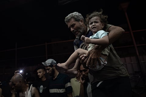 Palestinianos feridos após ataque de Israel a Khan Younis chegam ao hospital Nasser, ao sul da Faixa de Gaza, na madrugada deste domingo.