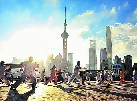Ao amanhecer, nas margens do rio Huangpu, os residentes de Xangai praticam Tai Chi Chuan, um dos exercícios matinais mais populares na China.