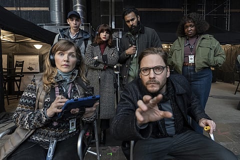 Daniel Brühl a fazer de realizador, com a "produtora" Aya Cash e o "assistente" Himesh Patel atrás e ao centro.