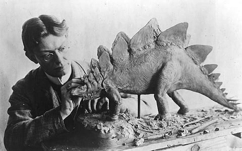 Na imagem, o paleoartista Charles R. Knight trabalha na figura de um stegossauro, em 1899