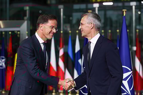 Mark Rutte (à esquerda) aperta a mão ao antecessor, Jens Stoltenberg