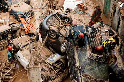 Socorristas inspecionam veículos atirados para as fundações de um edifício em construção em Paiporta.
