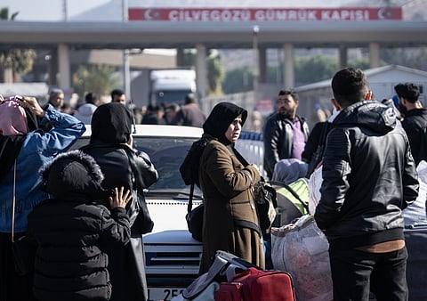 Sírios esperam para entrar no seu país vindos da Turquia na fronteira de Cilvegozu, em Hatay.