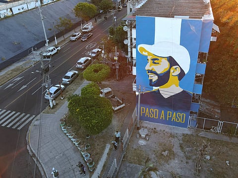 Um mural com o rosto do presidente Bukele na empena de um edifício em San Salvador.