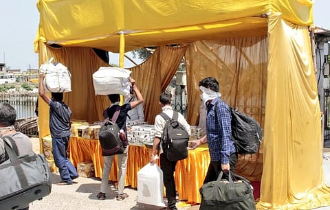 देवघर में सूरत से आने वाले श्रमिकों को प्रशासन की ओर से फूड पैकेट दिए गए। Photo: Twitter/@DCDeoghar