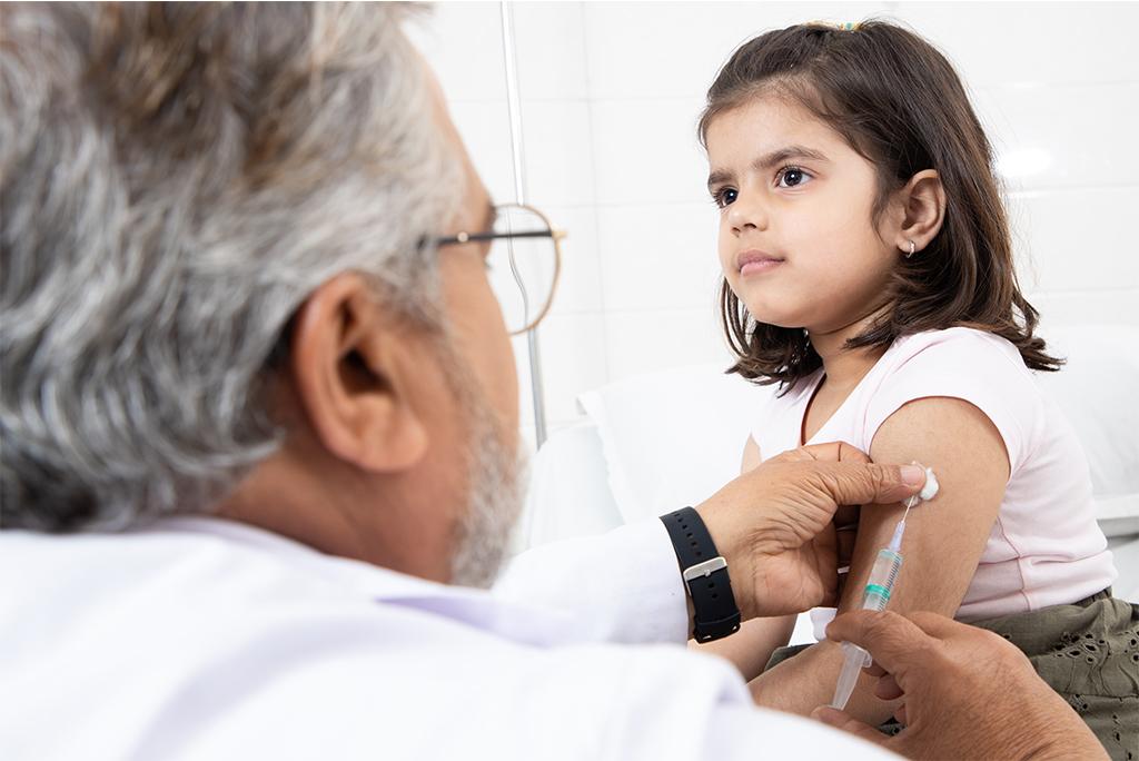 भारत में एक छोटी लड़की का टीकाकरण करते वरिष्ठ बाल रोग विशेषज्ञ; फोटो: आईस्टॉक