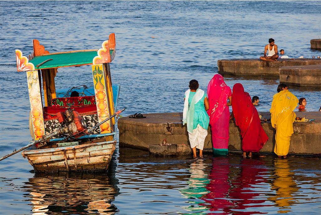 पवित्र नर्मदा के घाट पर सुबह की पूजा करती महिलाएं; फोटो: आईस्टॉक