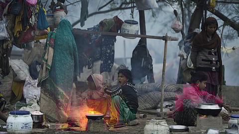 People warm themselves near a makeshift fire on a cold winter morning, in New Delhi (PTI)