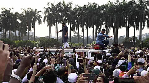 People gather around an ambulance carrying the body of leading Bangladeshi activist Sharif Osman Hadi, who died from gunshot wounds sustained in an attack in Dhaka earlier this month, following his funeral prayers outside the nation's Parliament complex in Dhaka, Bangladesh 