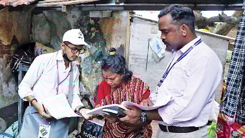 Booth-level officer (BLO) distributing the SIR forms to the public. 