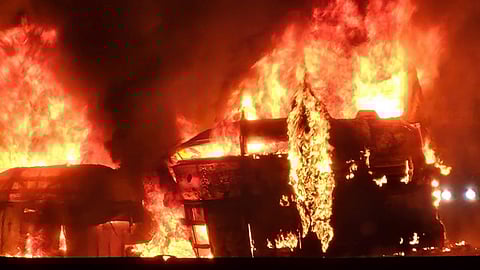 People gather after a speeding truck crashed against a luxury sleeper bus, which caught fire under the impact, in Chitradurga, Thursday, Dec. 25, 2025
