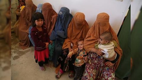 Women refugees sitting with their children