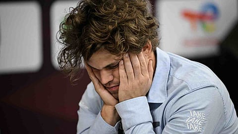Magnus Carlsen reacts after losing a piece during the tournament 