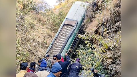 People gather around a damaged bus which fell-off a deep gorge, in Almora district, Uttarakhand, Tuesday, Dec. 30, 2025. 