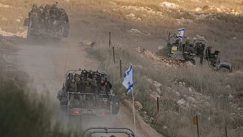 Israeli soldiers cross the security fence moving towards the so-called Alpha Line that separates the Israeli-annexed Golan Heights from Syria, in the town of Majdal Shams.