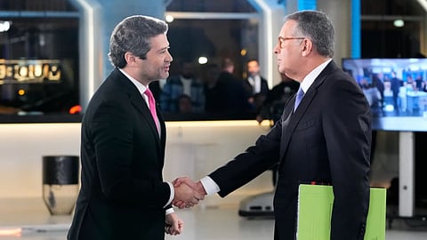 Presidential candidates Antonio Jose Seguro, of the center-left Socialist Party, right, and Andre Ventura, of the populist Chega party, shake hands before a television debate ahead of the presidential election, in Lisbon