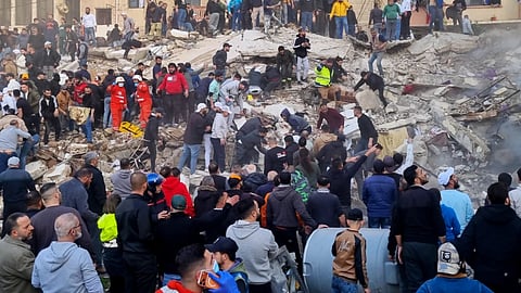 Rescue workers and residents search for survivors in the rubble of a building that collapsed in the northern city of Tripoli, Lebanon