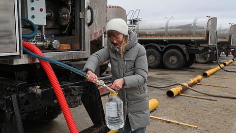 A woman gets drinking water distributed by authorities in the city of Donetsk in the Russian-controlled part of eastern Ukraine.