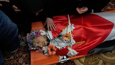 Mourners take the last look at the body of Palestinian-American Nasrallah Muhammad Jamal Abu Siyam, 19, who according to the Palestinian Health Ministry was shot by settlers on Wednesday night, during his funeral in the West Bank village of Mukhmas, east of Ramallah.