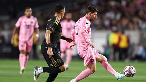 Inter Miami forward Lionel Messi, right, passes against Los Angeles FC midfielder Mark Delgado (8) dribbles the ball during the first half of an MLS soccer match in Los Angeles, Calif.