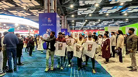 In this image received on Feb. 20, 2026, Indian Youth Congress (IYC) workers stage a 'shirtless protest', walking around holding T-shirts with slogans against the government and the India-US trade deal printed on them, at the AI Impact Summit, in New Delhi.