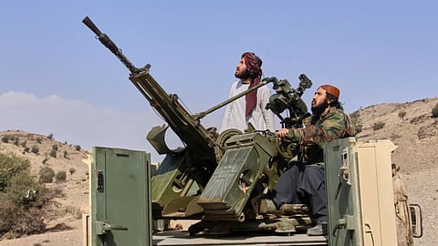 Taliban fighters look up while manning an armed pickup truck at the Afghan side of the Ghulam Khan crossing with Pakistan in Khost province, Afghanistan, Friday, Feb. 27, 2026. 