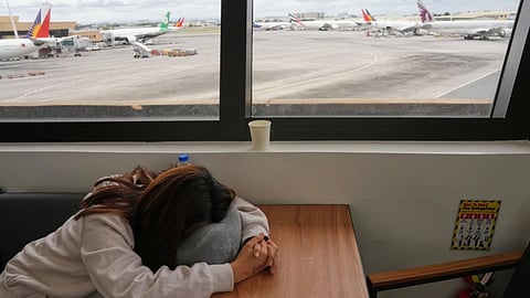 An overseas Filipino worker sleeps as she waits for updates on her cancelled flight to the Middle East at Manila's International Airport, Philippines.