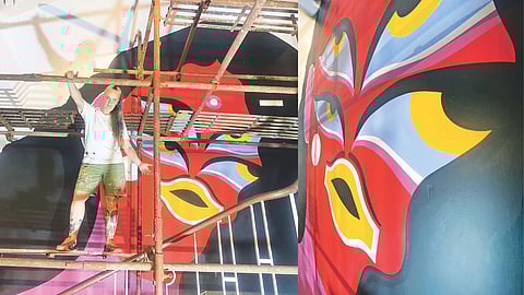 A mural that is part of the Wall Art India series; (l) Kashnik in front of the mural