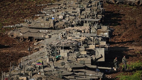Israeli soldiers work on tanks at a staging area in northern Israel near the border with Lebanon.