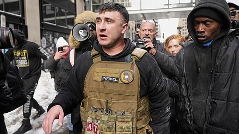Jake Lang, center, walks away from counter protesters after an altercation near Minneapolis City Hall, Saturday, Jan. 17, 2026, in Minneapolis