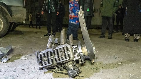 People look at fragments of a Russian drone that hit residential neighbourhood during air attack in Kharkiv, Ukraine.