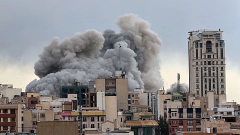 A plume of smoke rises after a strike in Tehran, Iran, Monday, March 2, 2026 