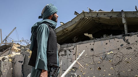 A Taliban soldier beside the building in Kandahar province reportedly hit by Pakistani airstrikes