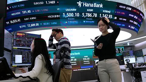 Currency traders work near a screen showing the Korea Composite Stock Price Index (KOSPI), top center, and the foreign exchange rate between U.S. dollar and South Korean won, top center left, at the foreign exchange dealing room of the Hana Bank headquarters in Seoul, South Korea, Thursday, March 19, 2026