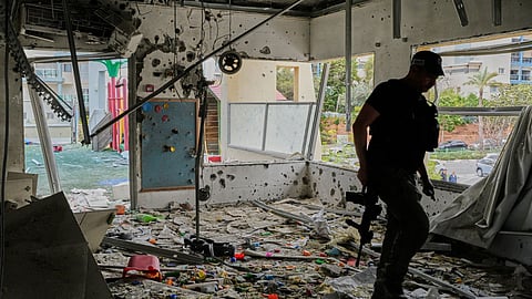 An Israeli policeman walks in a kindergarten hit by fragments of an Iranian missile in Rishon LeZion, Israel, Saturday, March 21, 2026. 