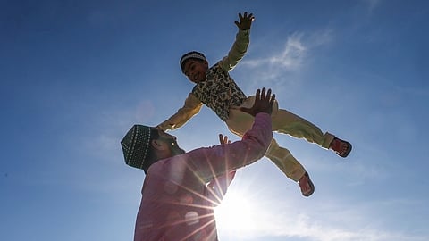 People from the Muslim community offer prayers as a child looks on, on the occassion of Eid Al-Fitr, at an Eidgah in Jammu, Saturday, March 21, 2026
