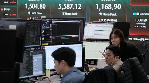 Currency traders watch monitors near a screen showing the Korea Composite Stock Price Index (KOSPI), top center, and the foreign exchange rate between U.S. dollar and South Korean won, top left, at the foreign exchange dealing room of the Hana Bank headquarters in Seoul, South Korea, Thursday, March 26, 2026. 