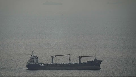 A cargo ship carrying vehicles sails through the Arabian Gulf toward the Strait of Hormuz in the United Arab Emirates