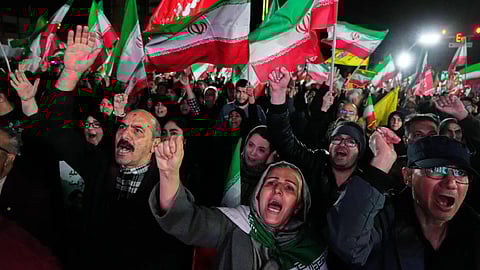 Pro-government supporters chant slogans and wave Iranian flags during a rally, in a square in western Tehran, Iran