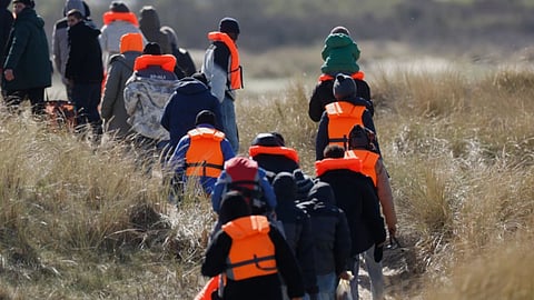 Migrants trying to reach Britain, walk on a beach shore in Gravelines, northern France
