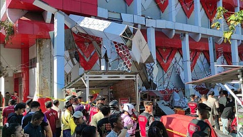 Onlookers gather as police officers inspect a damaged building following an earthquake in Manado, North Sulawesi, Indonesia